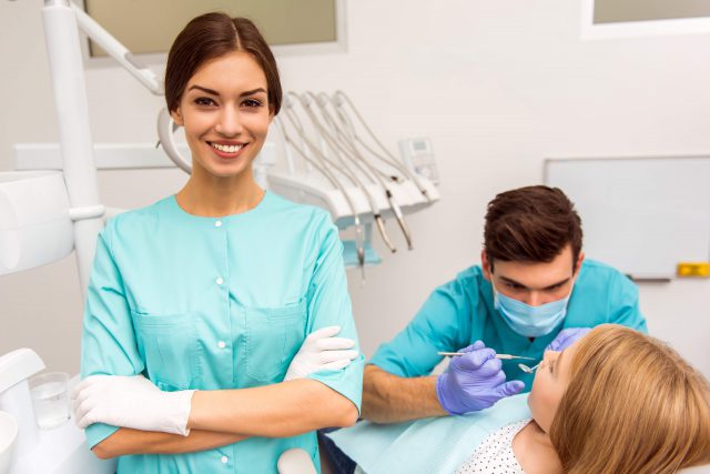 Dental Assistamt is with a dentist and a patient