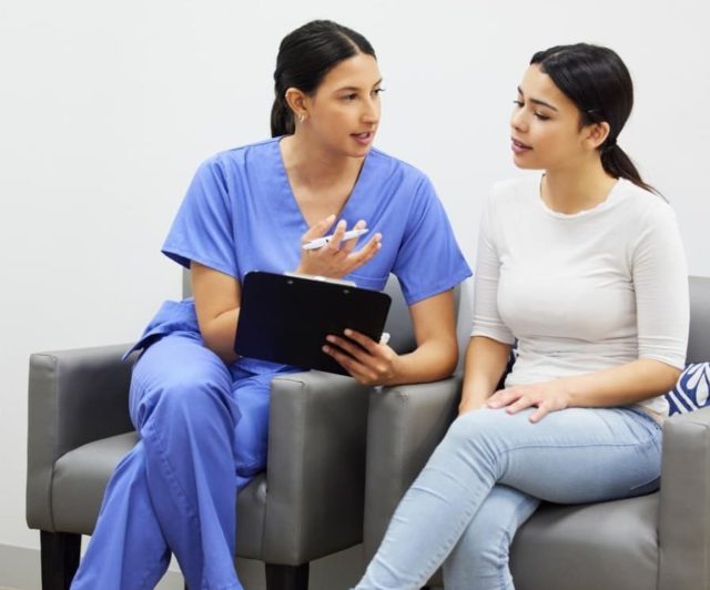 Medical assistant speaking with a patient