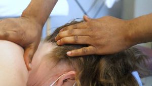 A close up of a man massaging a womans neck