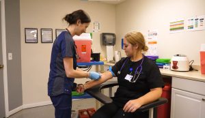 medical assisting students practice placing a needle