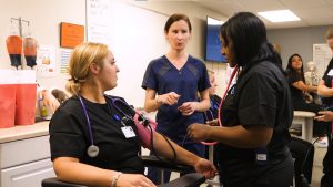 Three medical assisting students in class at First Institute